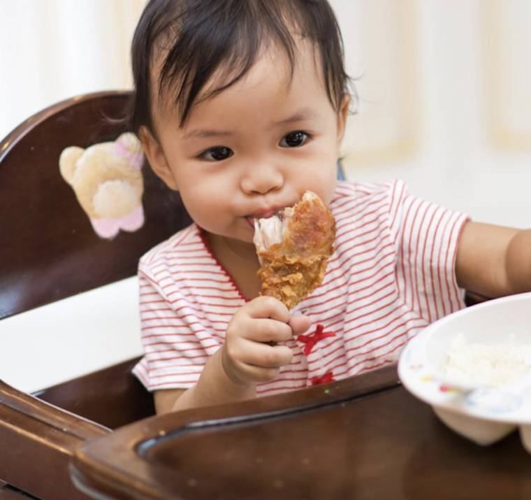 baby eating chicken