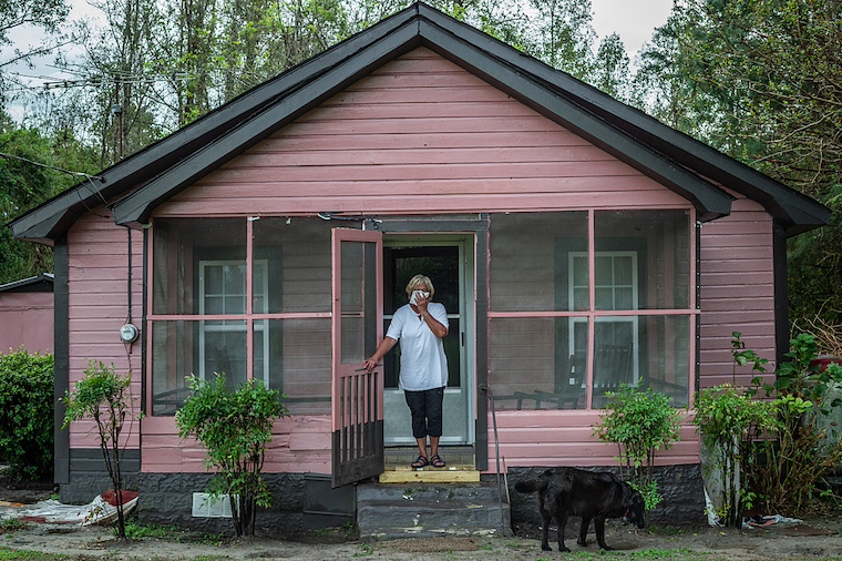 activist on porch holding a handkerchief over mouth